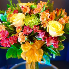 Bouquet of yellow roses and pink alstroemeria with a gold ribbon