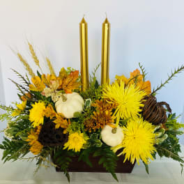 Autumn floral centerpiece with yellow blooms, white pumpkins, and gold candles