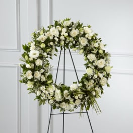 White floral wreath on a black stand