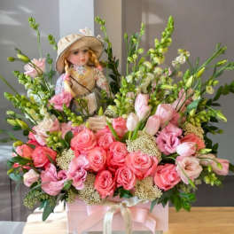 Pink rose bouquet with a doll centerpiece in a pink box
