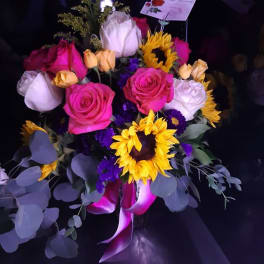 Bouquet of pink and white roses with sunflowers and purple accents
