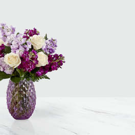 Purple and white bouquet in a faceted purple vase
