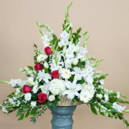 White and red floral arrangement in a basket on a pedestal vase