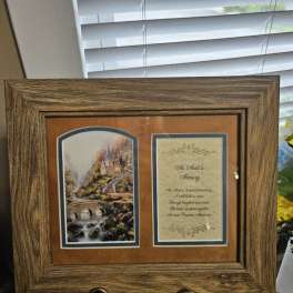 Wooden memorial frame with a printed tribute and landscape scene
