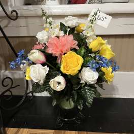 Mixed bouquet of white, yellow, pink, and blue flowers in a vase