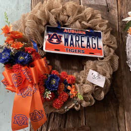 A floral wreath with an Auburn license plate and orange ribbon