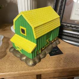 Decorative green and yellow house figurine on a shelf
