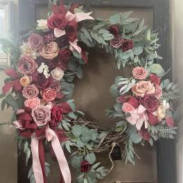 Heart-shaped floral wreath with pink and burgundy roses and eucalyptus