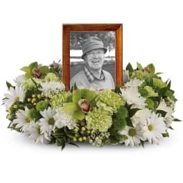 Framed black-and-white portrait surrounded by white and green flowers