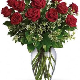Red roses arranged in a clear glass vase