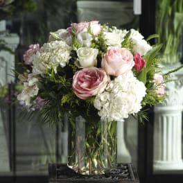 Pink and white rose bouquet in a clear glass vase