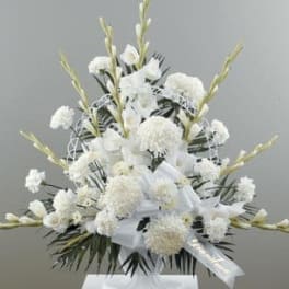 Fan-shaped white gladiolus, carnations, and mums in a pedestal sympathy arrangement