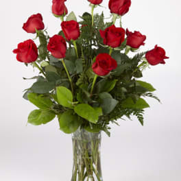 Red roses arranged in a clear glass vase