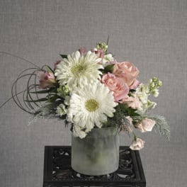 Pink roses and white daisies in a frosted vase