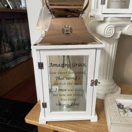 White lantern with "Amazing Grace" text and a candle inside