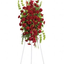 Tall standing spray of red roses and greenery on a white easel