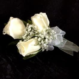 Three white rose boutonniere with baby's breath and sheer ribbon