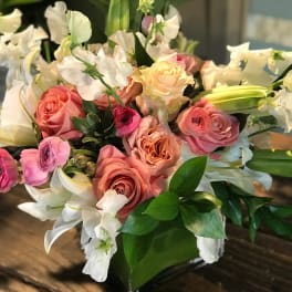 Bouquet of pink and peach roses with white lilies and orchids