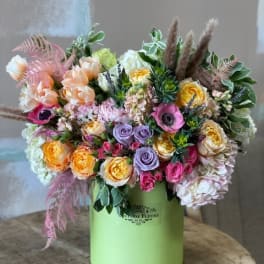 Mixed pastel bouquet in a green hatbox