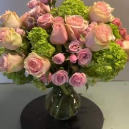 Pink roses and green hydrangeas in a glass vase