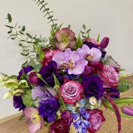 Bouquet of pink, purple, and lavender flowers in a gold vase