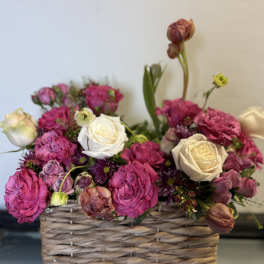 Pink and white roses arranged in a woven basket