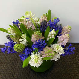 Bouquet of purple, white, and pink hyacinths in a green vase