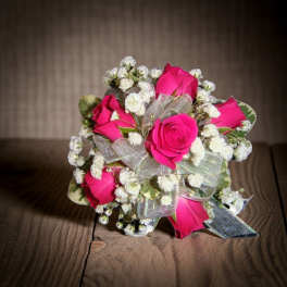 Bouquet of hot pink roses with small white filler flowers and a silver ribbon