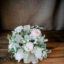 Small bouquet of pale pink roses with ribbon and variegated greenery
