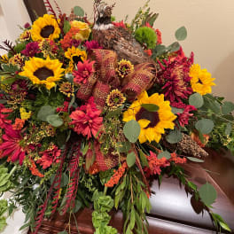 Large floral casket spray with sunflowers and a pheasant centerpiece