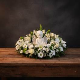 White floral arrangement with an angel figurine centerpiece