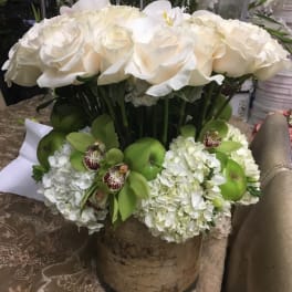 White rose and orchid arrangement in a birch-style container
