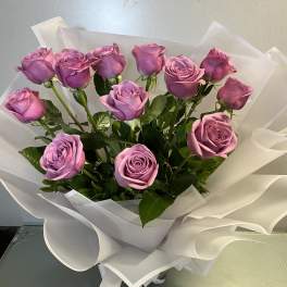 Bouquet of lavender roses wrapped in white paper
