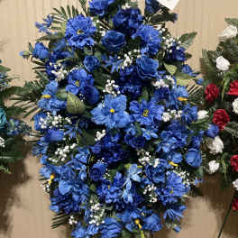 Large blue floral standing spray with mixed blooms and greenery