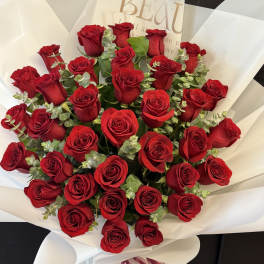 Bouquet of red roses wrapped in white paper