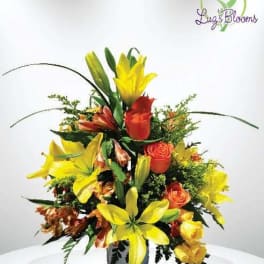 Bright bouquet of yellow lilies and orange roses in a vase