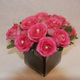 Pink roses arranged in a square glass vase