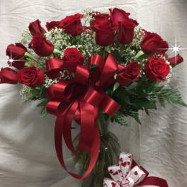 Bouquet of red roses with a red ribbon in a glass vase