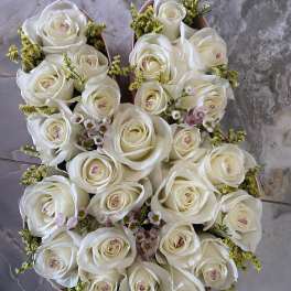 Round bouquet of white roses with small pink filler flowers