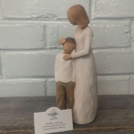 Wooden figurine of a mother holding a child, with a small product card in front