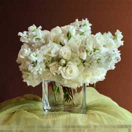 White roses and hydrangeas in a clear glass vase