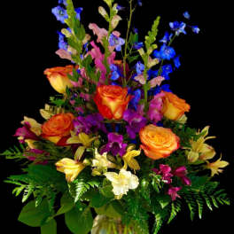 Colorful bouquet of roses, snapdragons, and alstroemeria in a glass vase