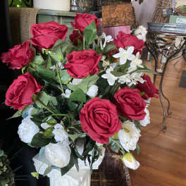 Red and white rose arrangement in a tall white vase