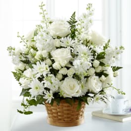 White roses and daisies arranged in a woven basket