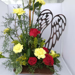 Red roses and yellow carnations arranged with angel wings