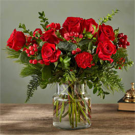 Red roses and carnations in a clear glass vase