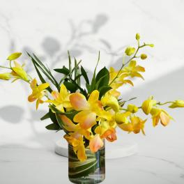 Yellow orchid arrangement in a glass vase