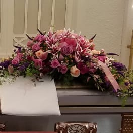 Large pink and purple floral casket spray with roses and lilies
