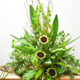 Tall green arrangement with sunflowers and fern-like foliage