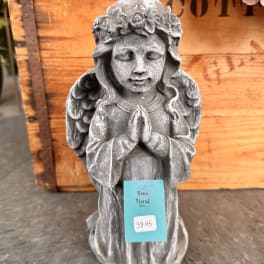 Gray praying angel statue with a floral crown